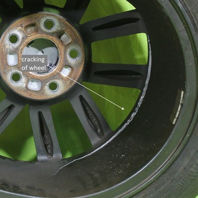 Front wheel 17 x 7J of a passenger vehicle (identified as WHEEL 2) that cracked exactly in the same location that the other front wheel broke.