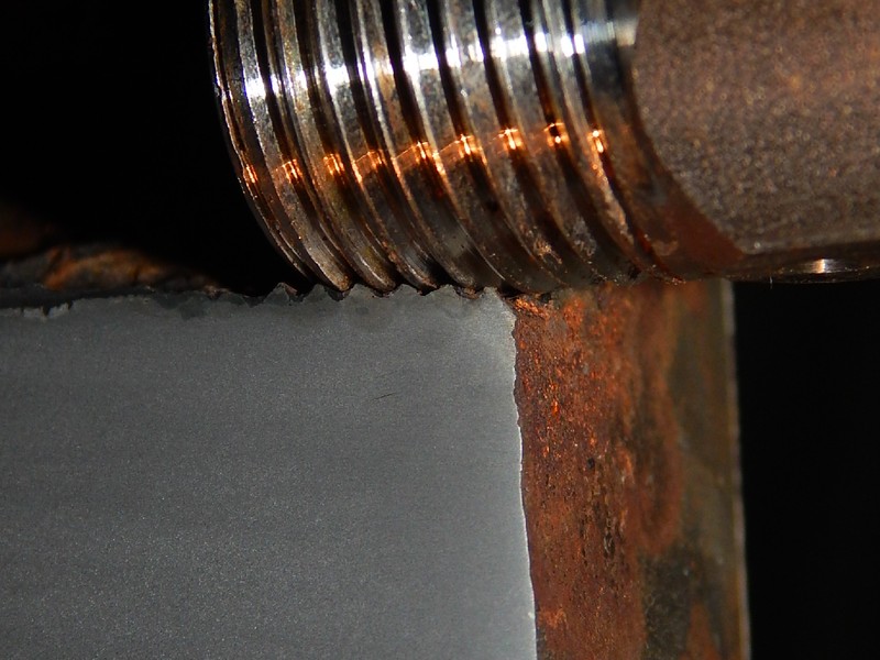 Macrosection detail of the valve body at the thread, showing the metal to metal contact between the carbon steel female thread and the stainless steel male thread.