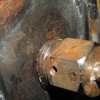The painting of the valve body was detaching at the vent location where the fitting was installed, not fully tighted.  Three threaded fillets were outside of the body.