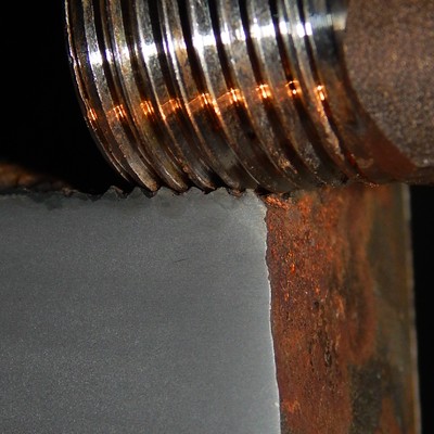 Macrosection detail of the valve body at the thread, showing the metal to metal contact between the carbon steel female thread and the stainless steel male thread.